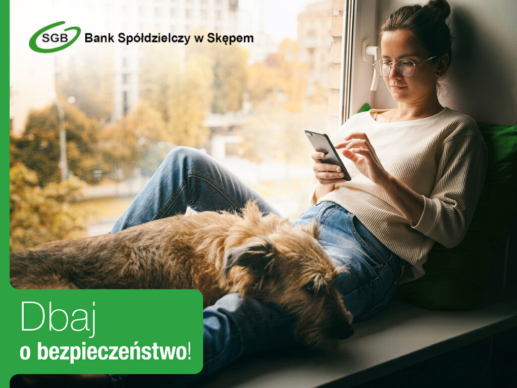 Kobieta siedzi używając telefonu; promuje bezpieczeństwo w bankowości.